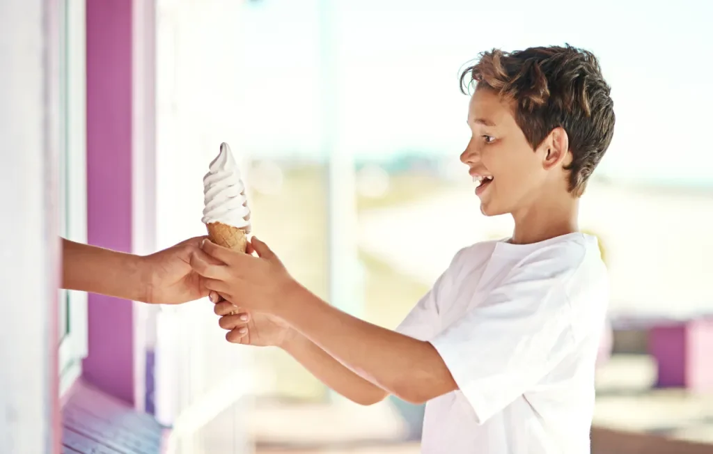 Shot of a happy young boy getting an ice-cream cone, possibly while having fun in the Pennsylvania Americana Region
