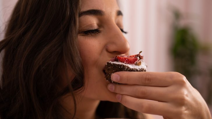 A woman eating a chocolate cupcake