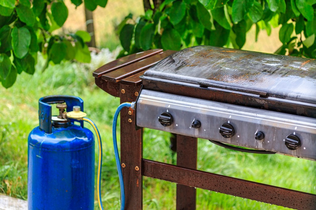 A gas barbecue connected to a propane tank. Some quick-connect fittings are also under a recall.