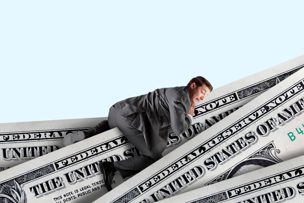 A scared man climbs over a series of U.S. dollars. Are RV dealerships going bankrupt?
