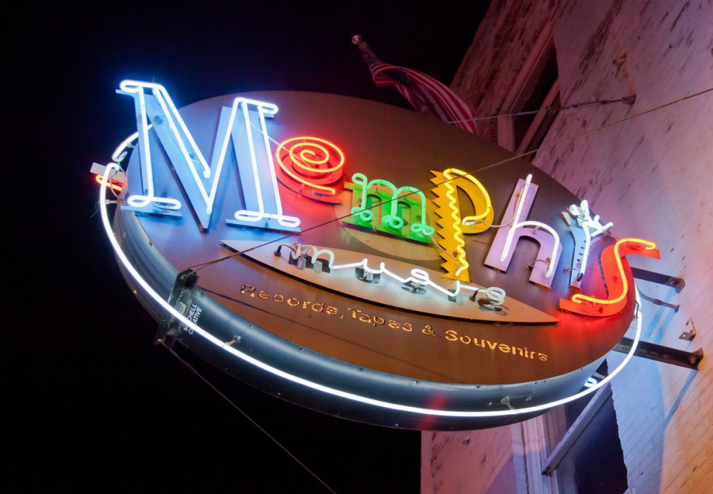 A Neon Memphis sign outside a music and souvenir shop on Beale Street. Be sure to explore Memphis while you're there for the music festival.