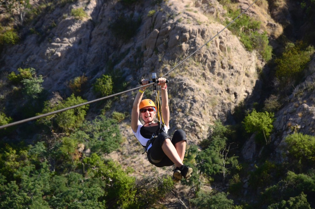 A woman on a zipline. Enjoy a zipline experience while you're exploring the area around Biosphere 2.