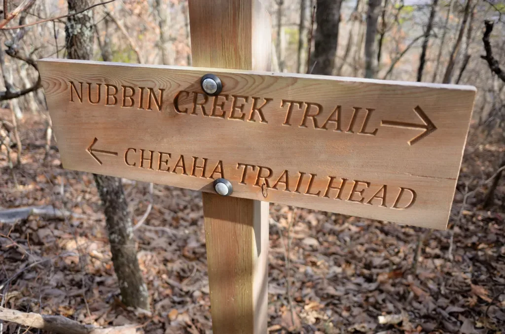 Close up of Nubbin Creek Trail and Cheaha Trailhead sign. You can visit Cheaha State Park when you travel to Alabama. 