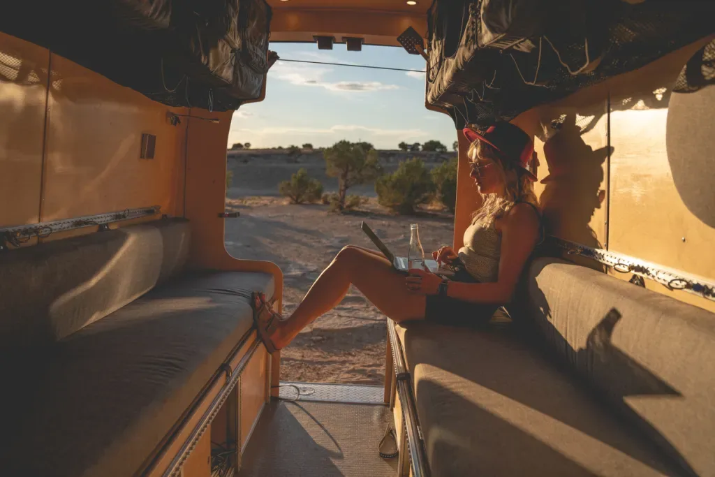 A woman sitting in her camper in fall sunlight