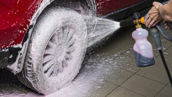 A foam cannon spraying foam onto a car tire