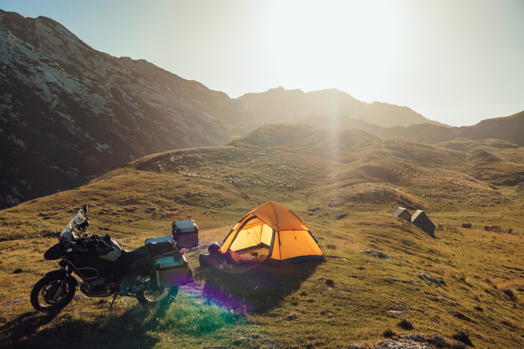 A tent and motorcyle in the mountains. Whether you use a motorcycle or a car, get outside!