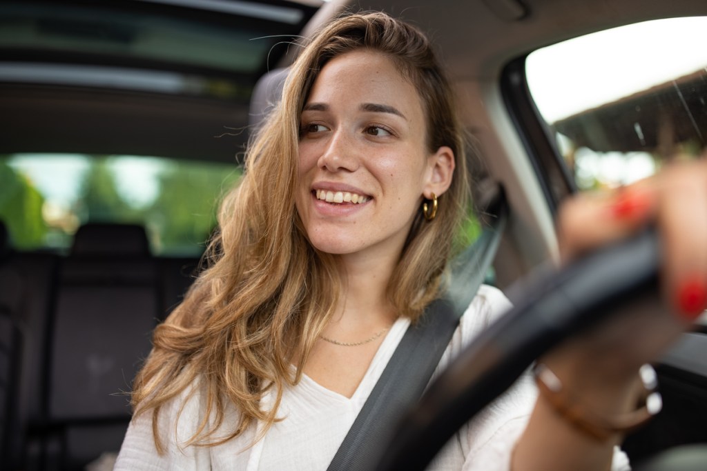 A woman driving a car. What harmful habits can be damaging your vehicle?