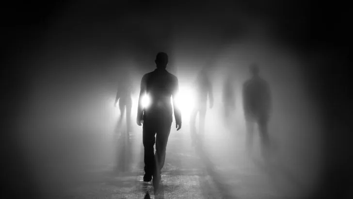 Silhouettes of people walking with light behind them. Are these skinwalkers?