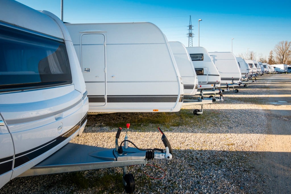 Travel trailers for sale lined up in a lot