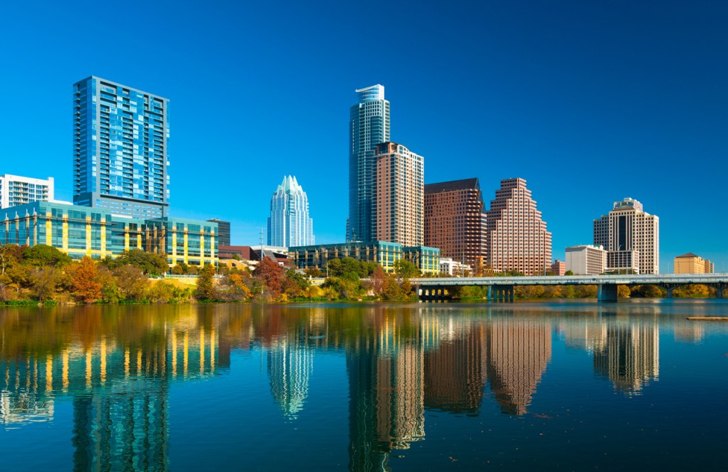 Austin downtown skyline during Autumn, with a reflection of the skyline on Lady Bird Lake in the foreground. You can certainly walk around this lake in Austin for under $20 - it's free!