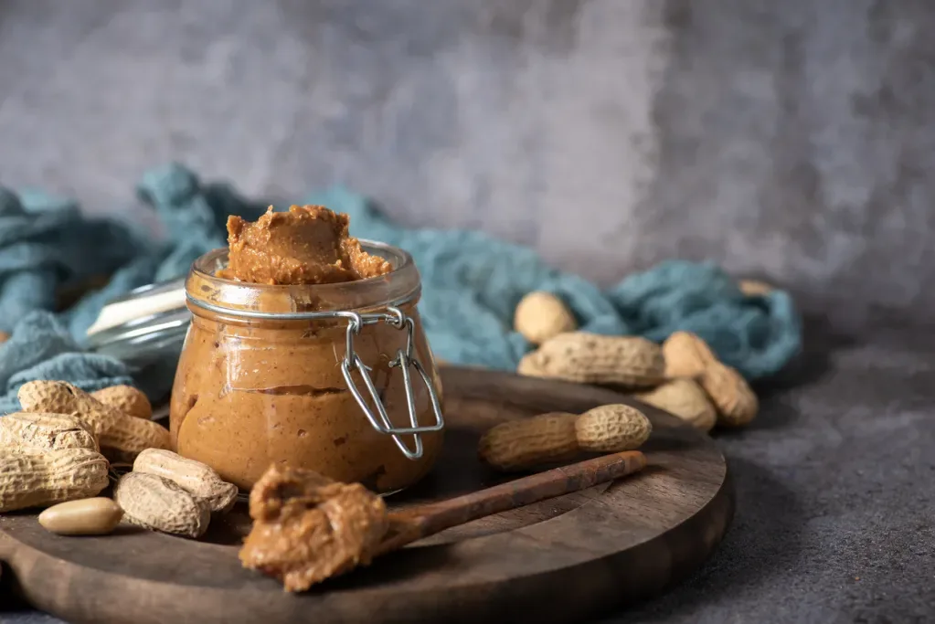 peanut butter with peanuts scattered around - the main ingredient for peanut butter soup