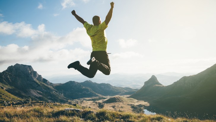Man jumping in the air in a mountain landscape - possible excited about Winnebago's new RV