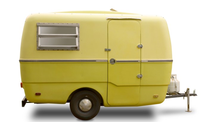 A yellow mini RV travel trailer