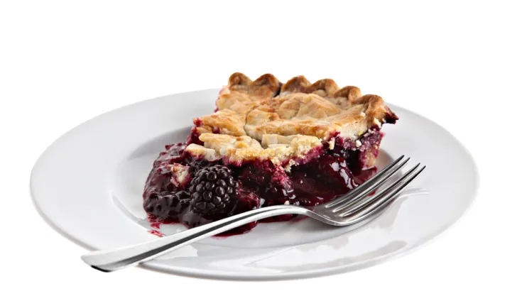 A slice of pie on a plate. Blackberries look very similar to marionberries