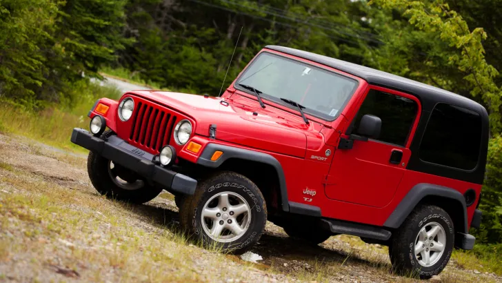 Jeep Wrangler TJ sitting on muddy dirt and gravel trail