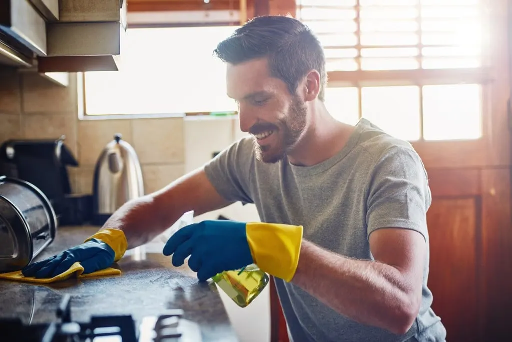 A man cleaning a kitchen surface at home - is he following our tips?