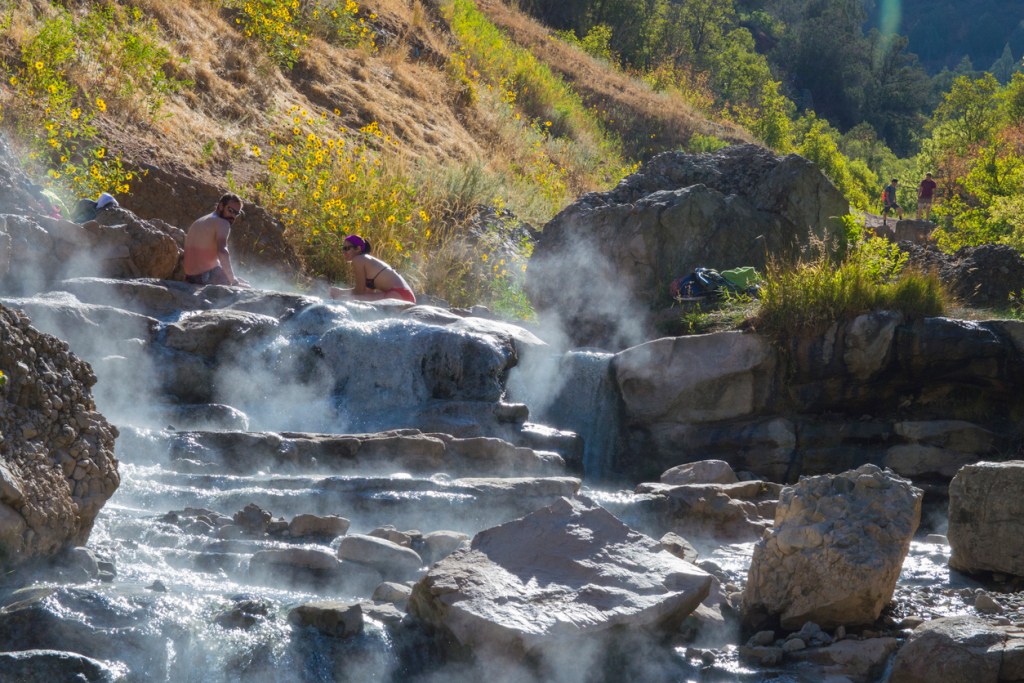 People enjoying natural hot springs maybe with a nearby rv park or campground