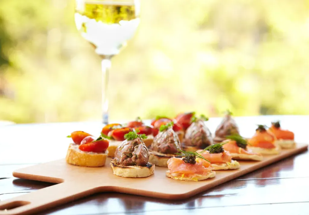 Fancy hors d'ouevres and a glass of white wine like you might see at a food festival