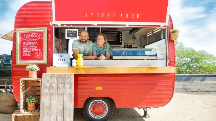 Red food truck and owners, perhaps in Austin, Texas.