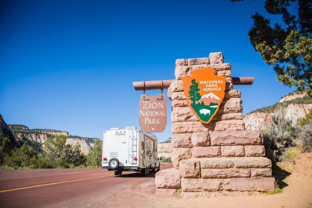 An RV driving into the entrance of Zion National Park. Arvie can help you get into hard to find RV spaces.