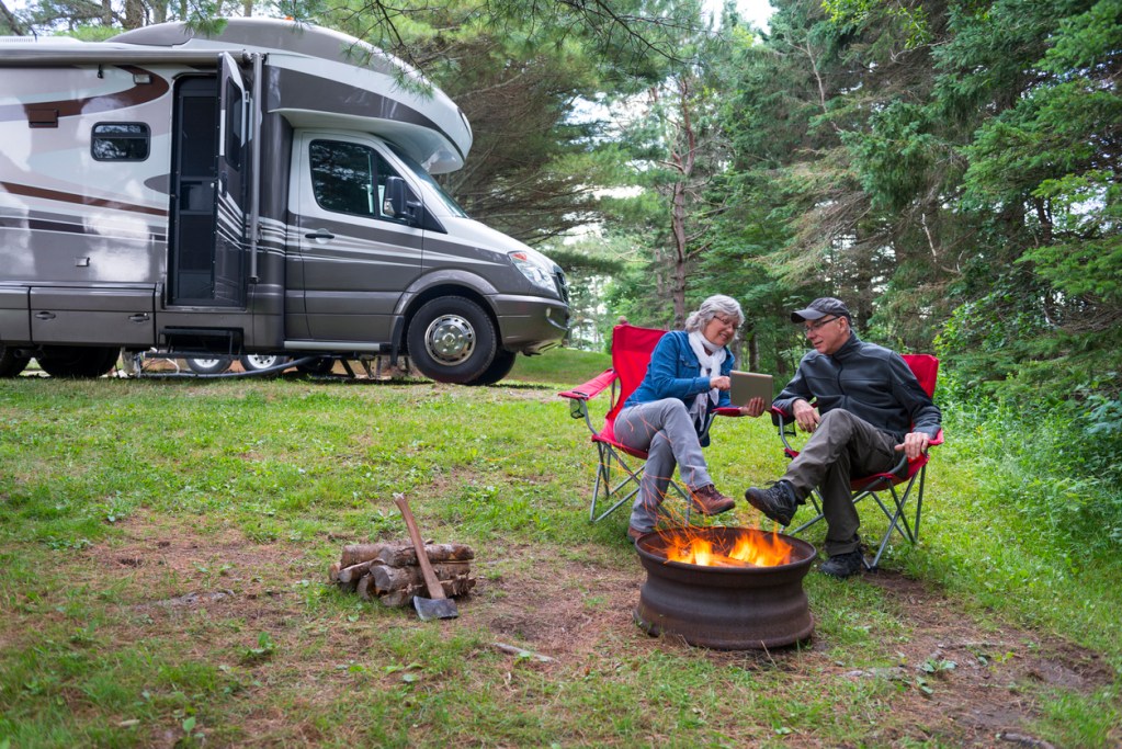A couple camping with their RV is happy because they made reservations with Arvie