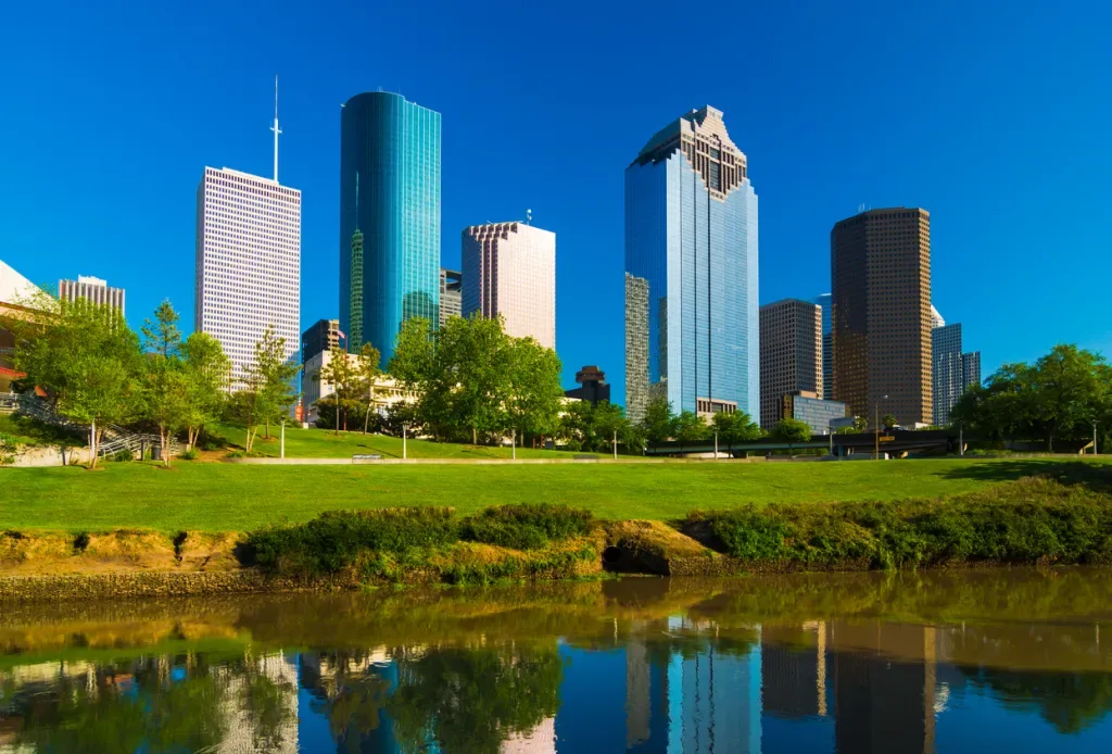 Houston downtown skyscrapers view / skyline view with the Buffalo Bayou River and park in the foreground.