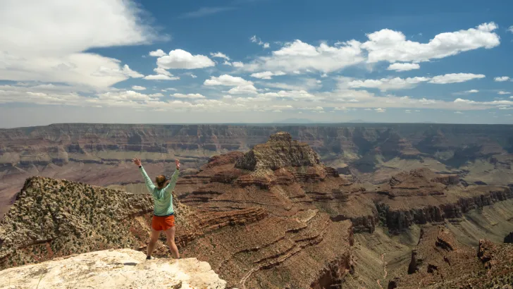 A woman posing on the edge of a dangerous cliff at the Grand Canyon