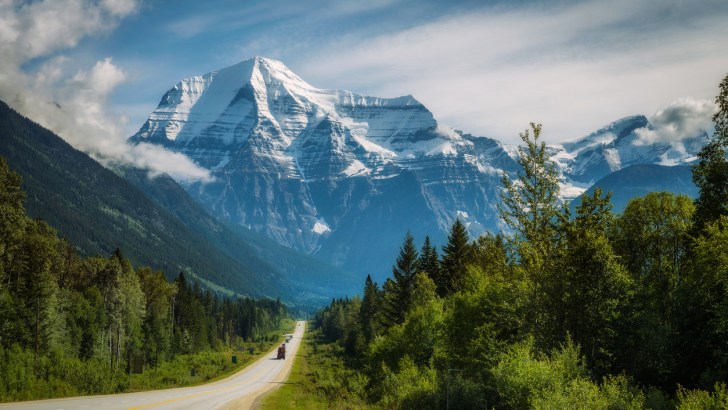 Scenic Yellowhead Highway stretches toward snow-capped mountains in Mt. Robson Provincial Park.