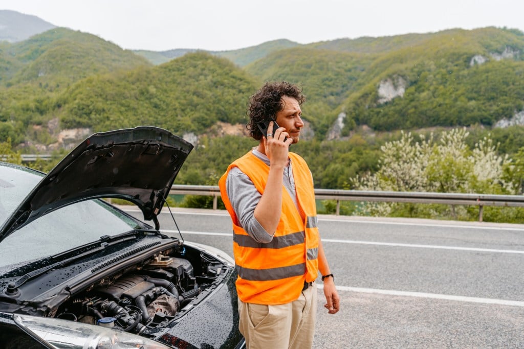 A man attempts to call roadside assistance from a remote location after his vehicle breaks down. Hopefully he isn't a boondocker without cell service. 