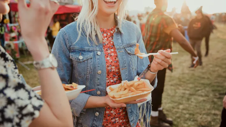 A woman eats tasty treats you might find at a June food festival.