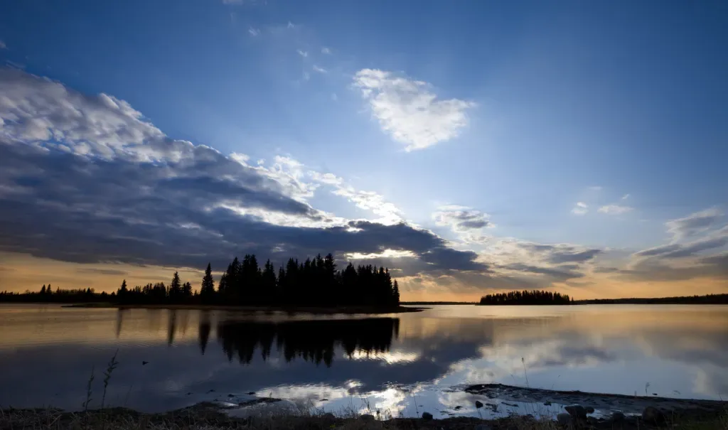 Sunset over a lake in Elk Island National Park, a great budget travel destination in Alberta.