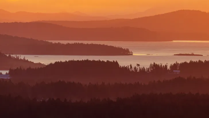 A misty orange sky as the sun rises over Vancouver Island, one of Western Canada's best travel destinations.
