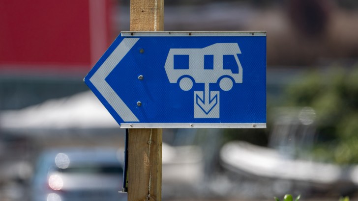 A blue sign with a white RV icon points the way to the nearest dump station.