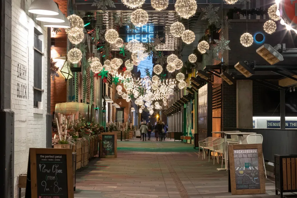 An alley in the Dairy neighborhood at night with spherical light fixtures strewn throughout.