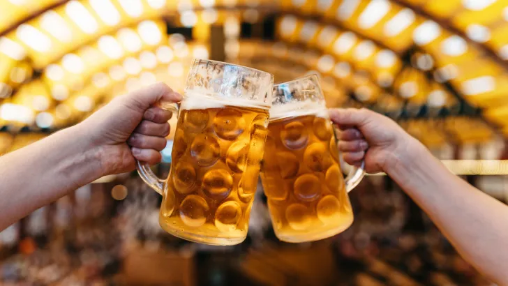 Two full beer steins cheers at a food festival, just like you might see in Denver.
