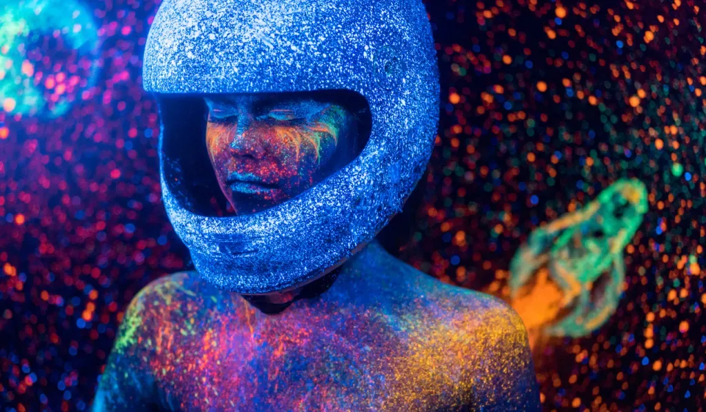 A colorful, artistic rendition of a woman in an astronaut helmet. While this isn't from Meow Wolf, it certainly fits the cosmic aesthetic.
